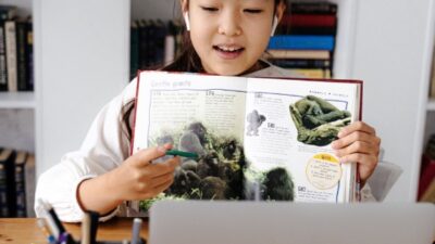 Niña frente a computador estudiando