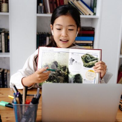 Niña frente a computador estudiando